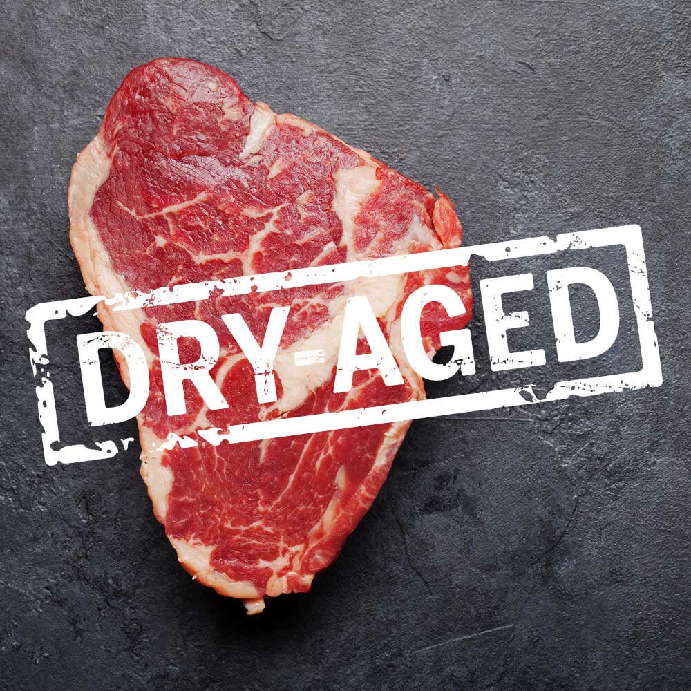 a quality cut of dry aged steak on a dark grey slate
